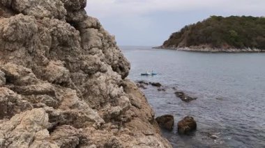 Genç çift, açık mavi bir kanoyla birlikte sarı raketlerle mutlu bir şekilde yol alıyorlar..