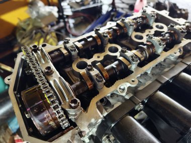 Garaj atölyesinde bir araba motoru tamiri yapılıyor..