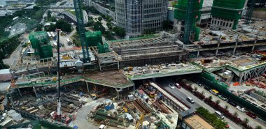 Hareketli bir şehirde bulunan bir inşaat alanını gösteren havadan bir perspektif..