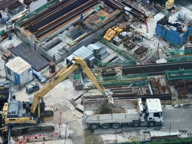 Hareketli bir şehirde bulunan bir inşaat alanını gösteren havadan bir perspektif..