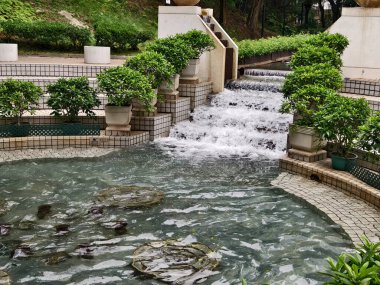 Parktaki güzel bir çeşme zarif bir şekilde merdivenlerle çevrilidir..