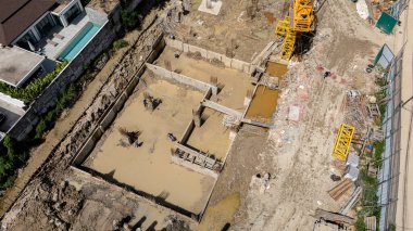 Çeşitli makine ve malzemelerin etrafa saçıldığı yoğun inşaat alanı.