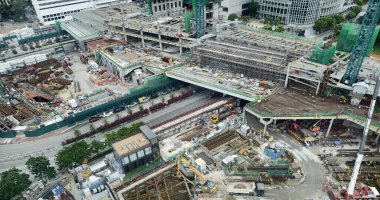 Hareketli bir şehirde bulunan bir inşaat alanını gösteren havadan bir perspektif..