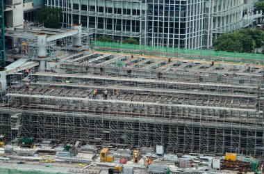 Hareketli bir şehirde bulunan bir inşaat alanını gösteren havadan bir perspektif..