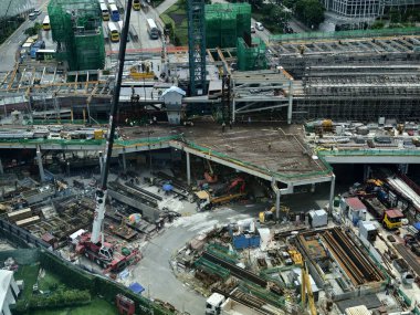 Hareketli bir şehirde bulunan bir inşaat alanını gösteren havadan bir perspektif..