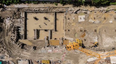 Çeşitli makine ve malzemelerin etrafa saçıldığı yoğun inşaat alanı.