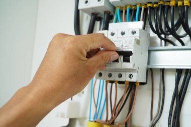 Elektrikçi sigortalı bir santrali kontrol ediyor..