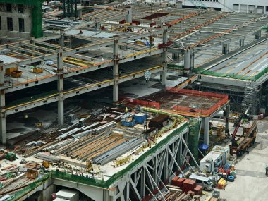 Hareketli bir şehirde bulunan bir inşaat alanını gösteren havadan bir perspektif..