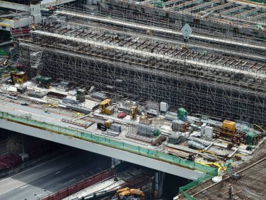 Hareketli bir şehirde bulunan bir inşaat alanını gösteren havadan bir perspektif..