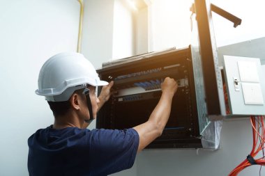 Bir bakım teknisyeni fiber optik merkezi olan bir sunucu odasında çalışıyor..