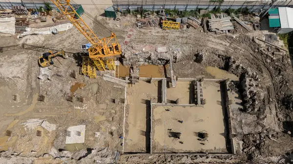 Çeşitli makine ve malzemelerin etrafa saçıldığı yoğun inşaat alanı.