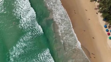 Kumlu sahile vuran dalgalarla dolu bir sahile..