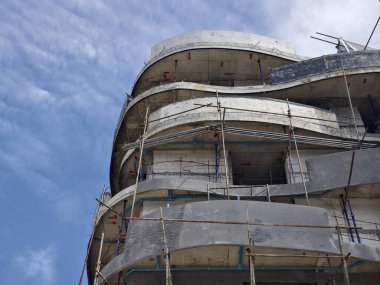 Mavi gökyüzünün arka planına karşı büyük bir bina inşa ediliyor..