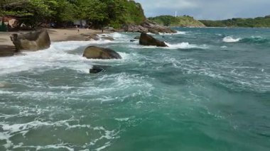 Dev okyanus dalgaları, büyük kaya taşlarıyla boş kumsallara çarpıp köpürüyor.. 