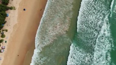 Kumlu sahile vuran dalgalarla dolu bir sahile..