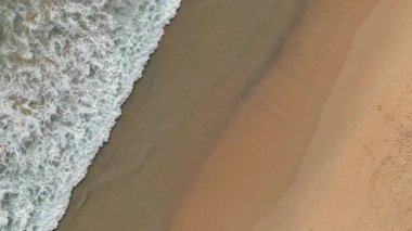 Kumlu sahile vuran dalgalarla dolu bir sahile..