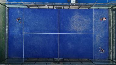 Mavi raket tenis kortlarındaki pratik yapan insanların havadan görünüşü.