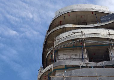 Mavi gökyüzünün arka planına karşı büyük bir bina inşa ediliyor..