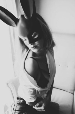 Siyah maskeli seksi çıplak kadın sandalyede poz veriyor..