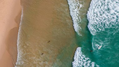 Kumlu sahile vuran dalgalarla dolu bir sahile..