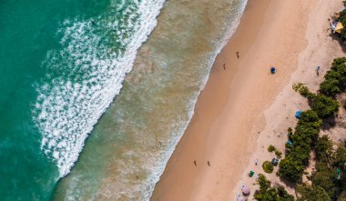 Kumlu sahile vuran dalgalarla dolu bir sahile..