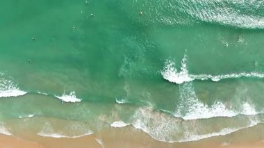 Kumlu sahile vuran dalgalarla dolu bir sahile..