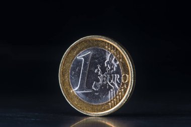 Eski bir euro sikkesi koyu metalik arka planda duruyor