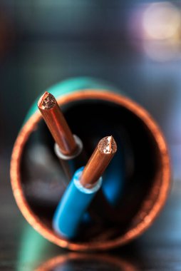 Korunma borusunda bakır kablo olan elektrik kablosu yakın plan, yansımaları olan metal bir yüzey üzerinde.