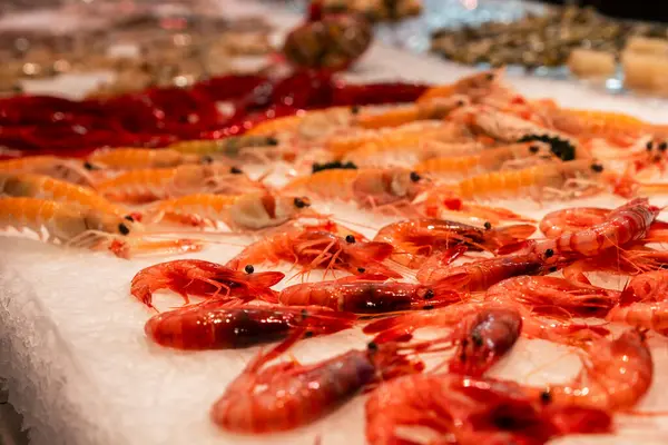 Taze karides, yerel gıda pazarındaki deniz ürünleri tezgahında buzun üzerinde duruyor.