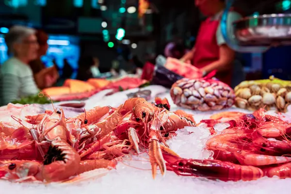 Yiyecek pazarı olan bir deniz ürünleri tezgahında buzun üzerine serilmiş taze karides.