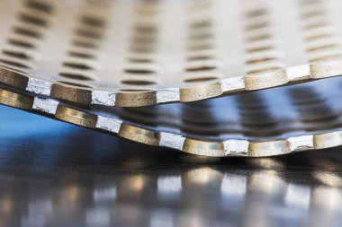 Delikleri olan kırık ve eğri metal yüzeyler, soyut endüstriyel eğriler ve ışık yansımaları.