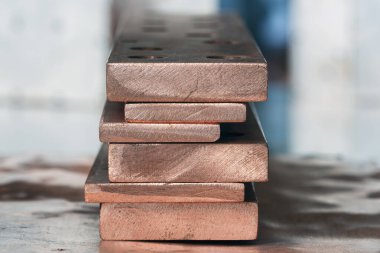 Endüstriyel alanda bir yığın bakır düz çubuk, enerji endüstrisi için bileşenler