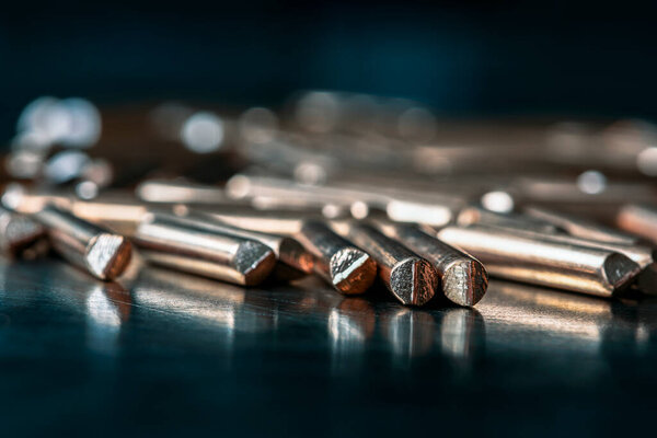 Copper wire scraps on an industrial metal surface illuminated by cold light, recycling of non-ferrous metals