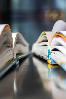 Bir kütüphanedeki metal bir masanın üzerinde uzanan kitapları aç, aşırı yakın çekim perspektifinden bak