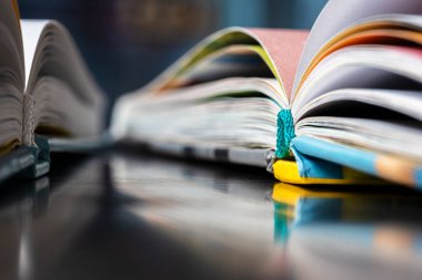 Kitapları bir kütüphanede metal bir masanın üzerinde, perspektiften bakıldığında aç