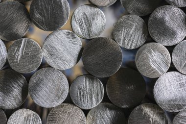 Fabrikadaki çelik çubuk yığını, metalürji endüstrisinin ürünü, yakın çekim görüntüsü.