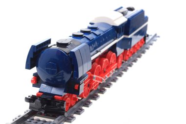 Lego parçalarından yapılmış plastik tren oyuncağı beyaz arka planda izole edilir.