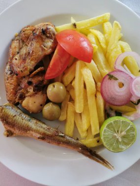 Kızarmış tavuk eti, patates ve ızgara sebze.