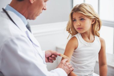 Sevimli küçük kız kim mahkeme sıva kolunu doktor ofisinde otururken üzerinde yapışmasını çocuk doktoru, bakıyor