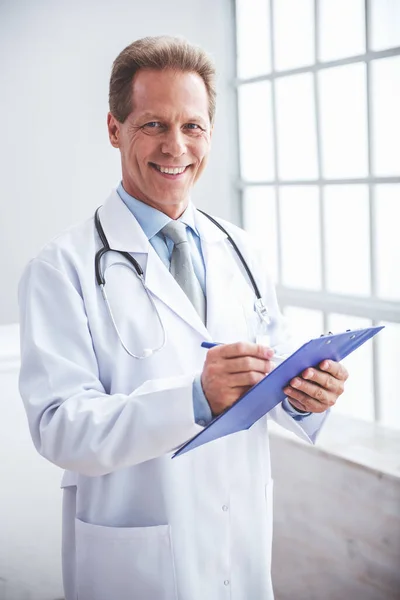 Όμορφος Μέσης Ηλικίας Γιατρός Λευκό Παλτό Ιατρική Λήψη Σημειώνει Κοιτάζοντας — Φωτογραφία Αρχείου