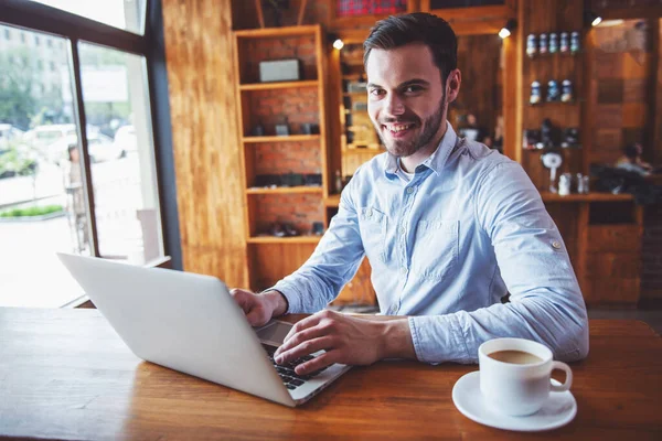 Przystojny Młody Biznesmen Jest Pomocą Laptopa Patrząc Kamery Uśmiechnięty Siedząc — Zdjęcie stockowe