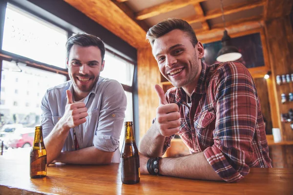 Dos Jóvenes Guapos Están Bebiendo Cerveza Mostrando Cartel Mirando Cámara — Foto de Stock