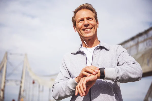 Handsome Middle Aged Man Sports Uniform Headphones Using His Watch — Stock Photo, Image