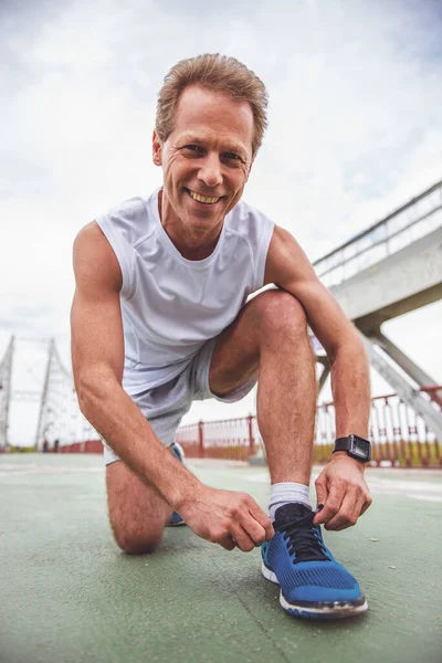 Yakışıklı Orta Yaşlı Adam Tek Tip Spor Ayakkabılarını Bağlama Kameraya — Stok fotoğraf
