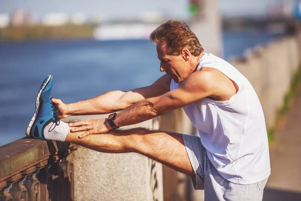 Sidovy Stilig Mitten Äldre Man Sport Uniform Stretching Lutande Bron — Stockfoto