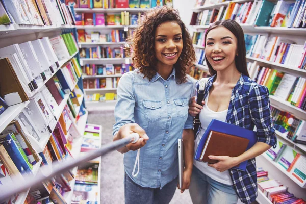 Atraktivní Studenti Drží Knihy Dívají Kameru Usmívají Zatímco Stojí Knihkupectví — Stock fotografie