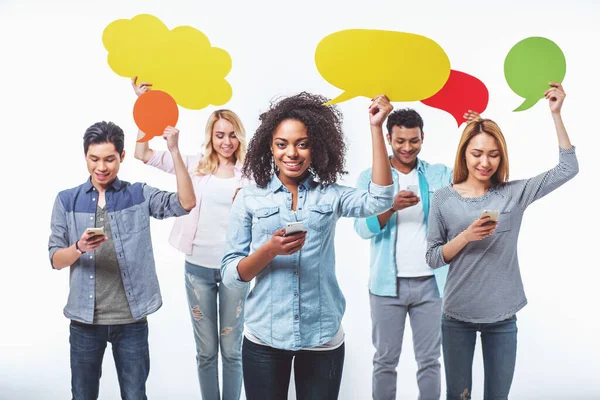 Young People Different Nationalities Speech Bubbles Using Smartphones Smiling Isolated — Stock Photo, Image