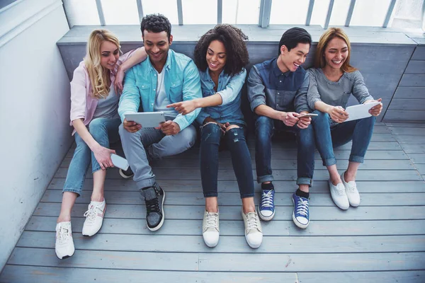 Jovens Diferentes Nacionalidades Estão Usando Gadgets Conversando Sorrindo Enquanto Estão — Fotografia de Stock