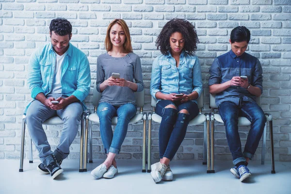 Unga Människor Olika Nationaliteter Använder Smartphones Fördriva Tiden Väntan För — Stockfoto
