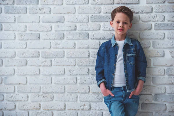Κομψό Μικρό Αγόρι Τζιν Ρούχα Κοιτάζει Την Κάμερα Και Χαμογελά — Φωτογραφία Αρχείου